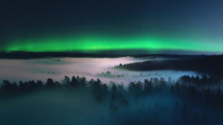 Green sky at night over a lake